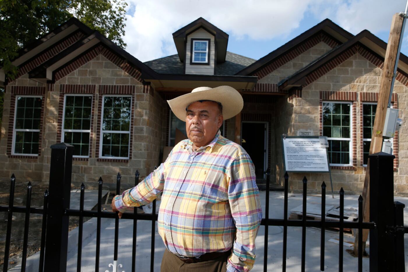 City Hall-backed housing developer Santos Coria stands in front of one of his houses on...
