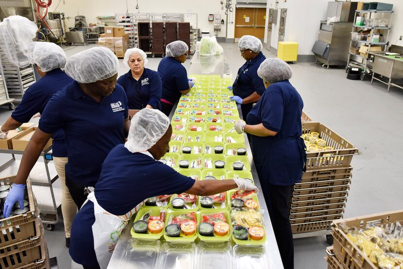 Personal de la cocina central del Dallas ISD prepara alimentos para el programa de comidas...