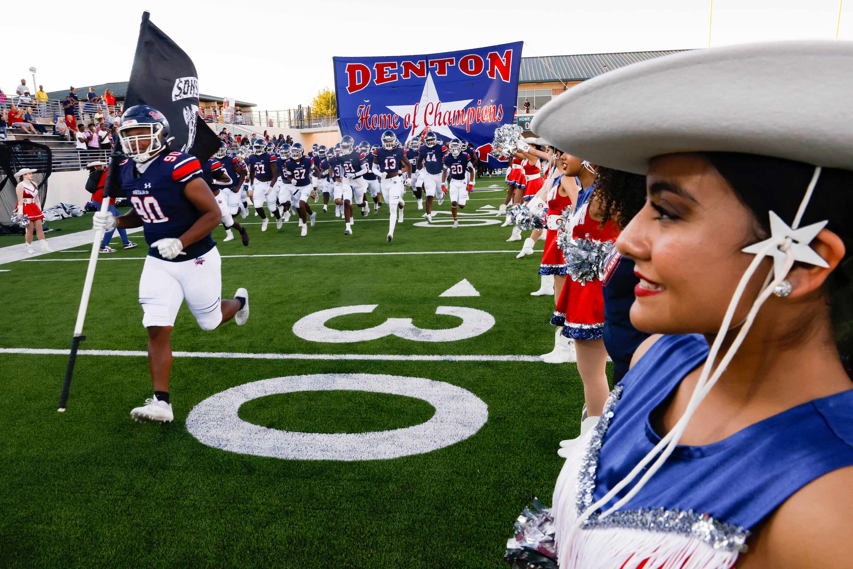 Denton Ryan football players run out before the start of their District 3-5A Division I game...