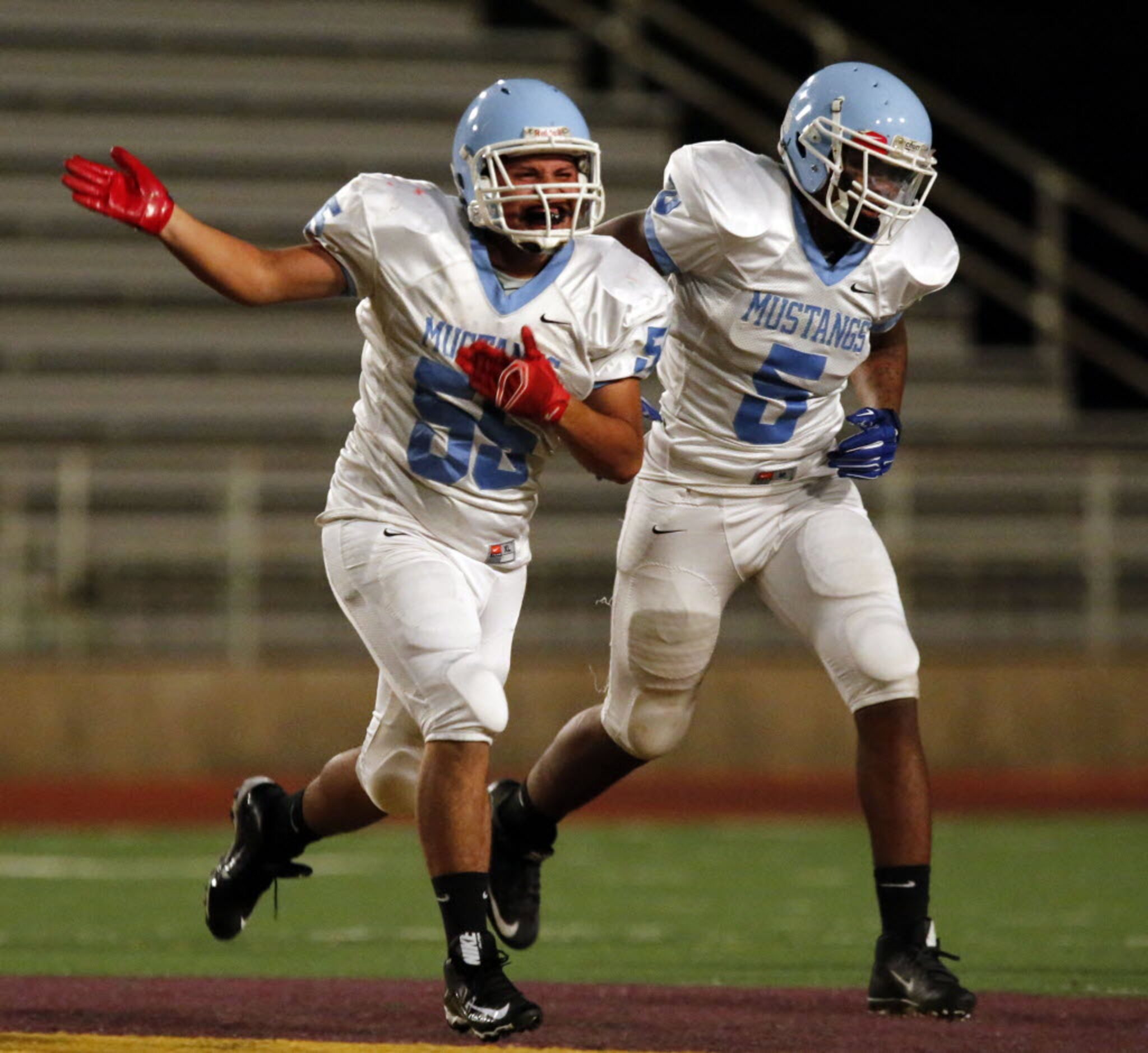 (TXHSFB) Roosevelt High's Jose Acalla (55) and Isreal Garcia (5) celebrate after Acalla...