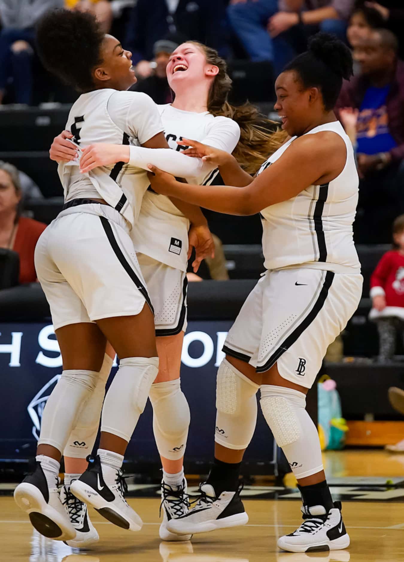 Bishop Lynch guard Maddie Cockrell (5) celebrates with guard Addison Knott (center) and...