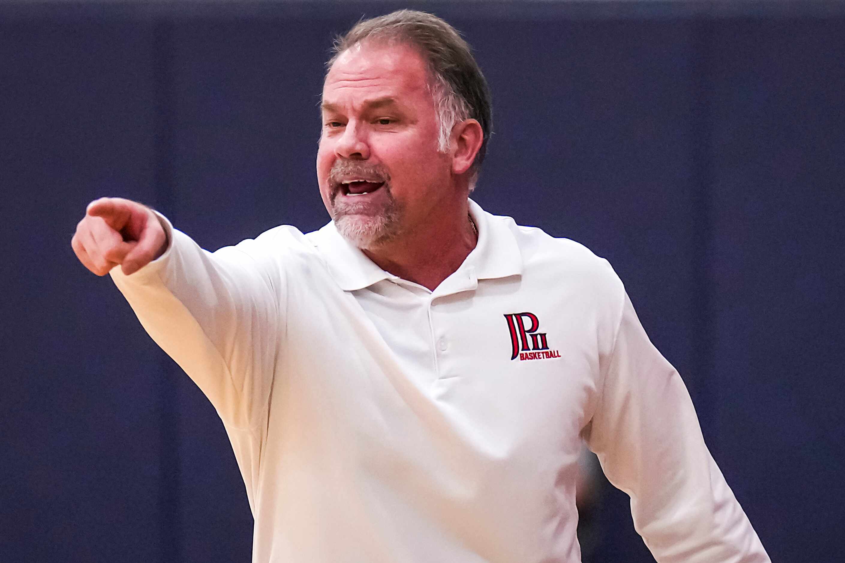 John Paul II head coach Dan Lee directs his team during a high school basketball game...