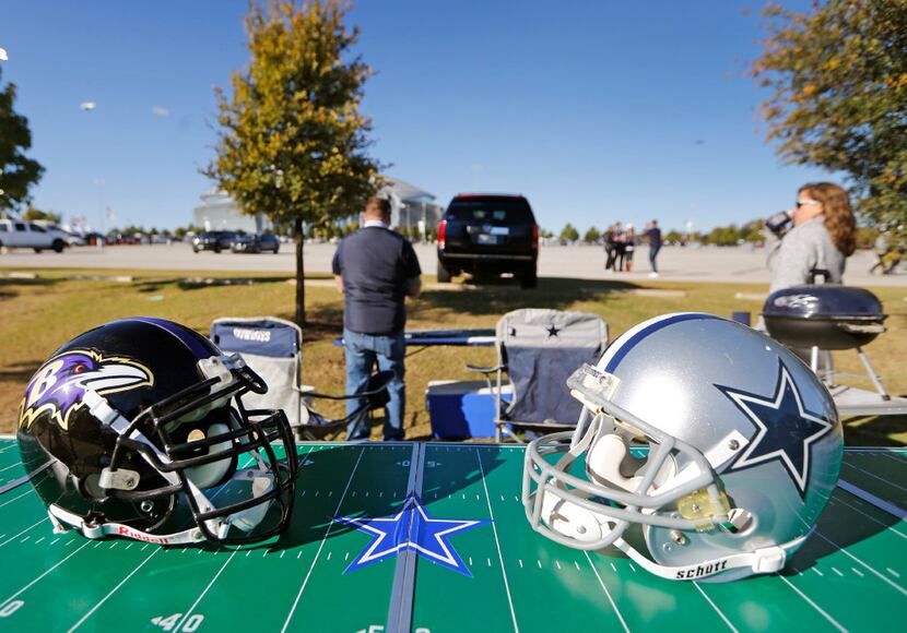 An appropriate display of NFL headgear shines in the morning sun as fans set up to tailgate...