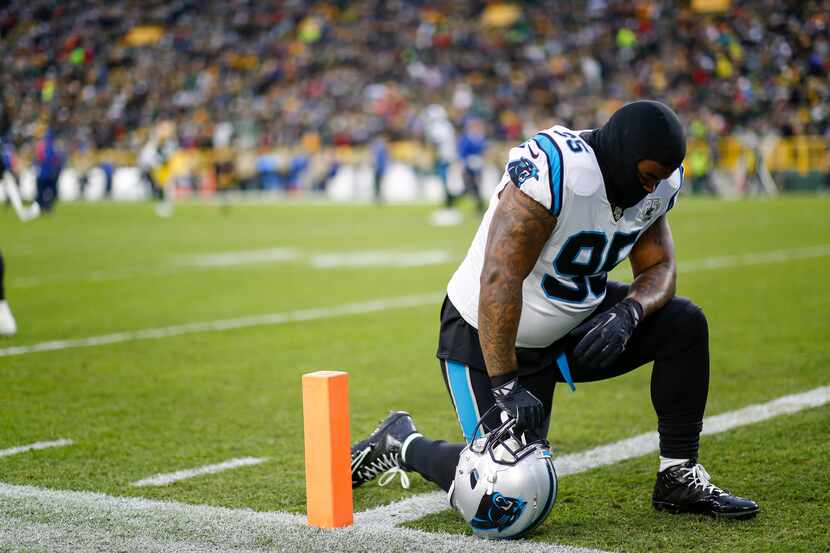 Carolina Panthers defensive tackle Dontari Poe kneels down on the field before an NFL...