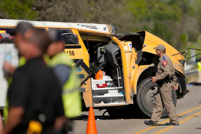 A Texas Department of Public Safety trooper inspects the scene of a fatal school bus crash...