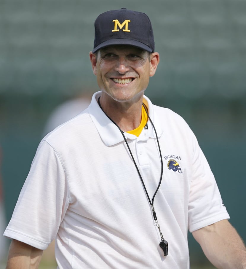 Michigan Wolverines head coach Jim Harbaugh smiles as he leads the Showtyme Elite Football...