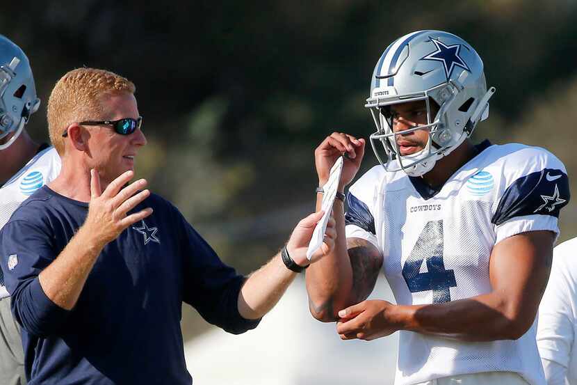 Dallas Cowboys head coach Jason Garrett, left, talks with quarterback Dak Prescott during...