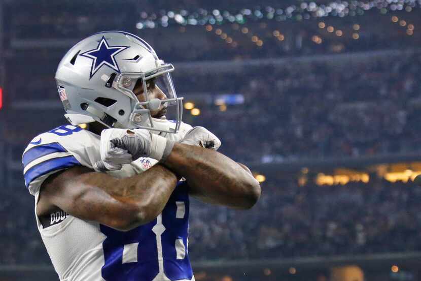 Dallas Cowboys wide receiver Dez Bryant (88) throws down the 'X' as he celebrates his...