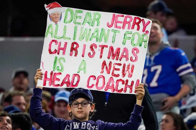 A fan holds a sign calling for the firing of Dallas Cowboys head coach Jason Garrett during...