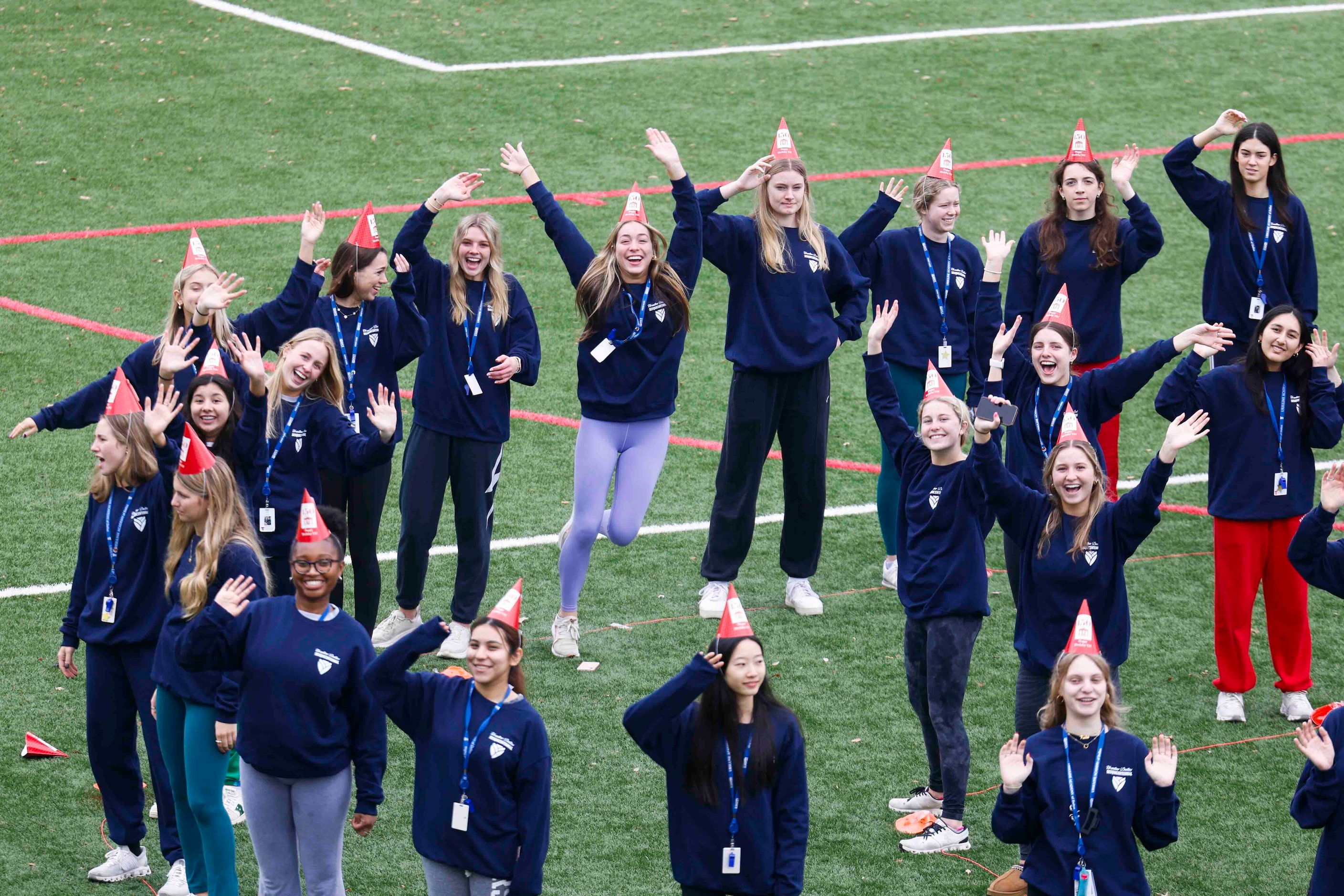 Students wave while standing in formation of "UA 150" for a giant group photo during the...