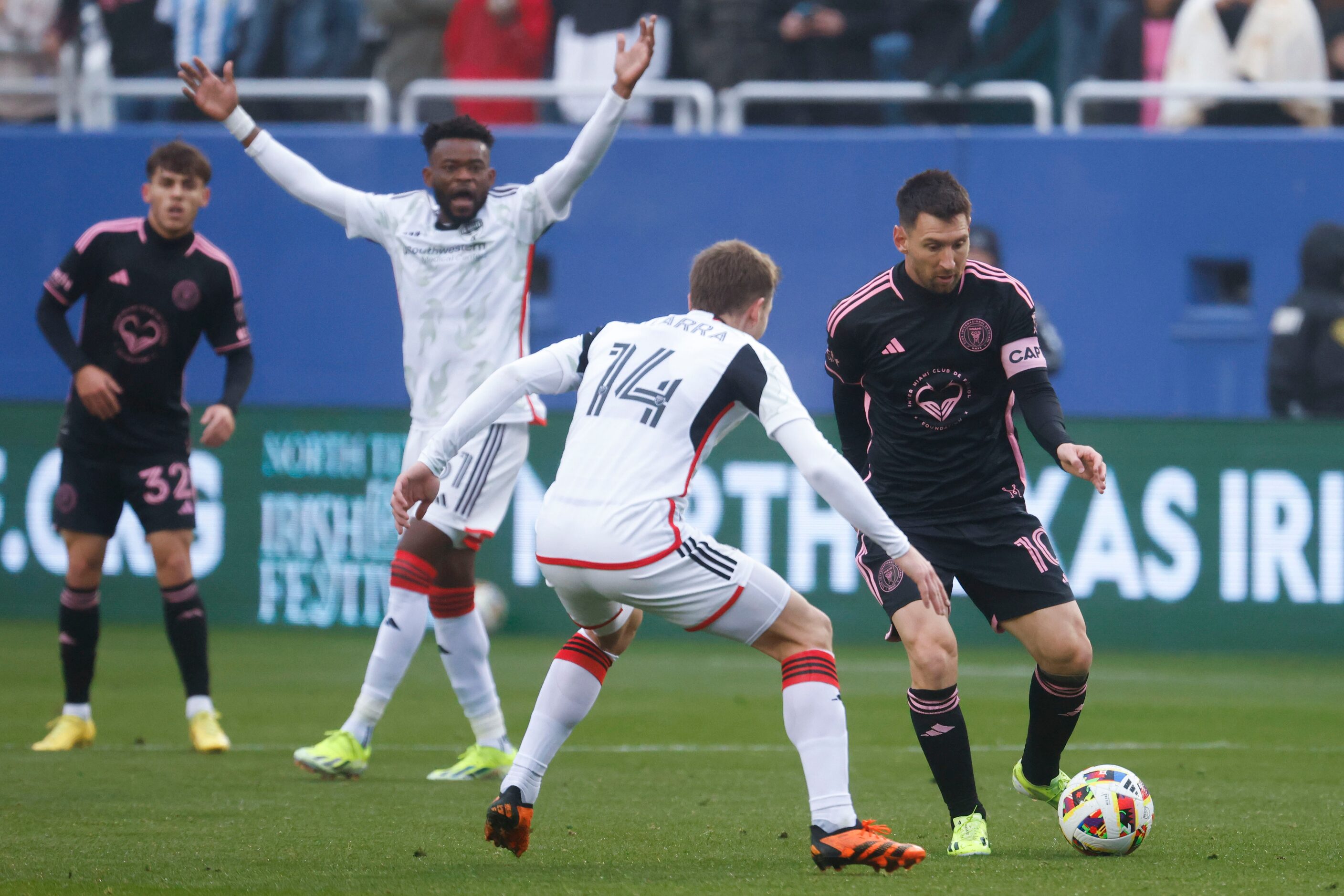 Inter Miami forward Lionel Messi (right) looks to dribble past FC Dallas midfielder Asier...