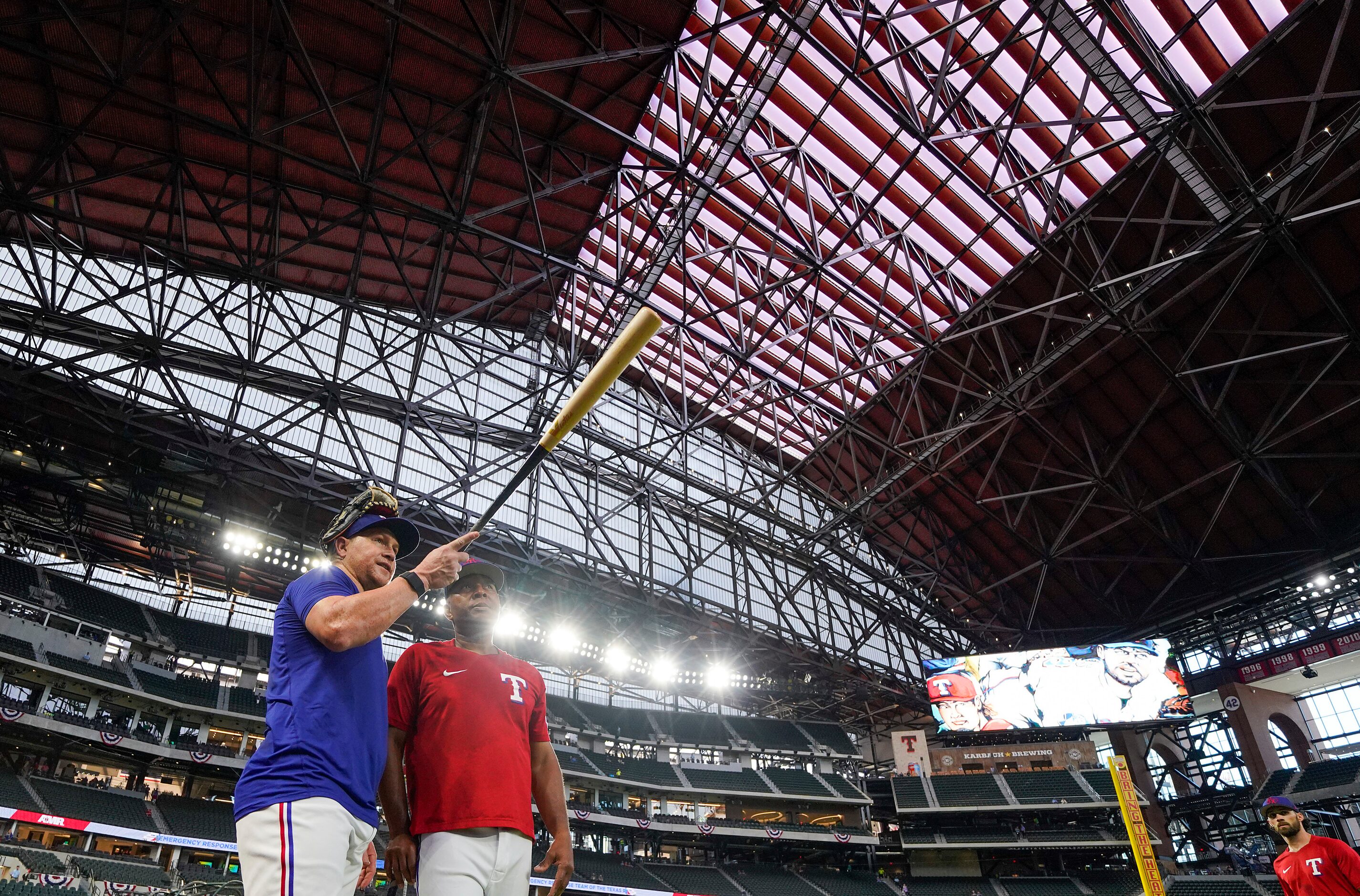 Texas Rangers right fielder Kole Calhoun looks out over the stadium with third base coach...