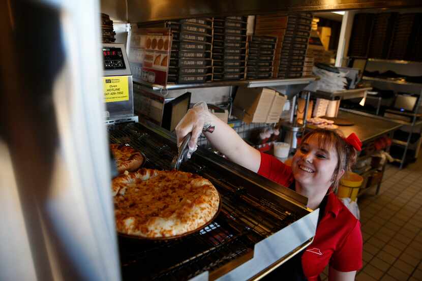  Assistant manager Candace Ledford picks a pizza out of the oven at the Pizza Hut in...