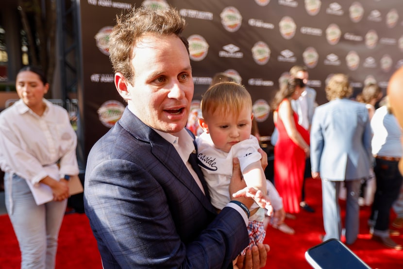 Robert Ratliff holds his son Henry as he speaks with reporters on the red carpet for the...