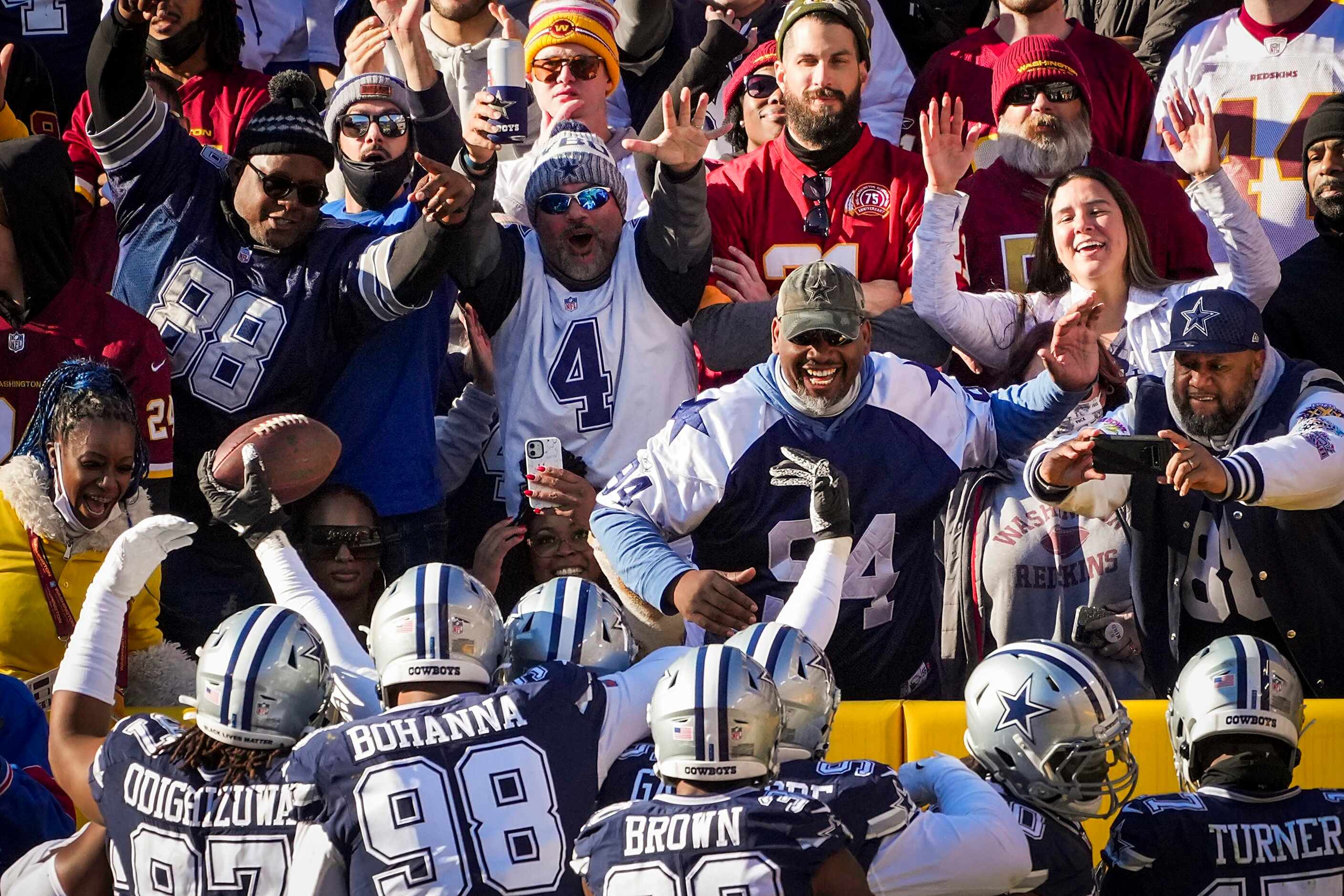 Fans cheer as Dallas Cowboys players celebrate around defensive end Dorance Armstrong after...