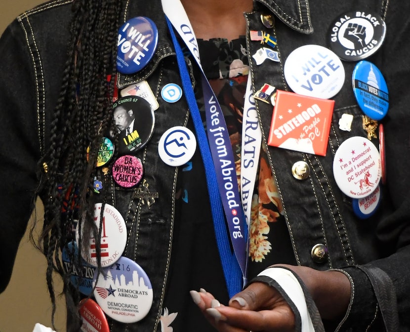 Adrianne George of Democrats Abroad wears pins at the Democratic National Committee's summer...