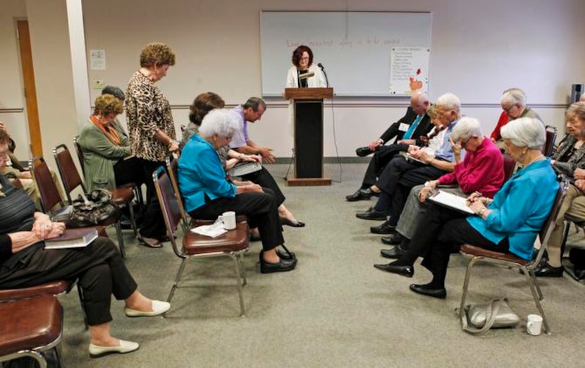 
Diane Hunt (left) prays for Louise Troh and her family at a Bible class Sunday at Troh’s...