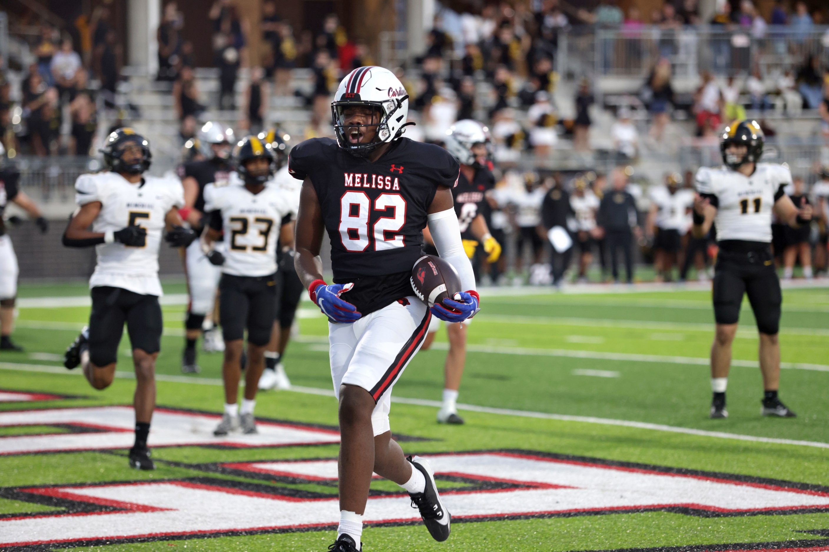 Melissa player #82 Reese Carter runs in for a touchdown during the Frisco Memorial High...