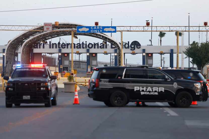 Pharr police officers sit Monday at the Pharr–Reynosa International Bridge, which remained...