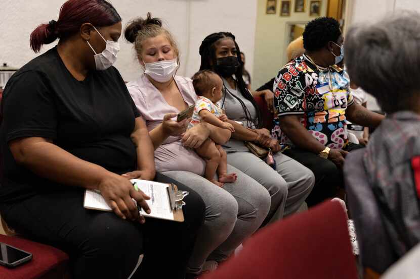 Brittany, a Hillcrest resident, shows a photo to Sandra Brown of her 3-month-old child,...