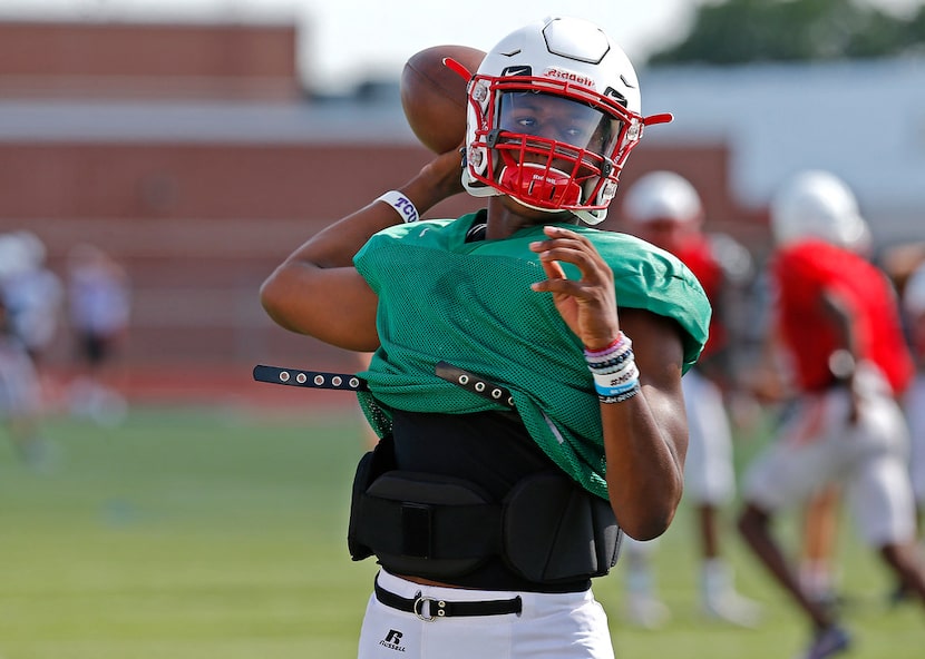 Quarterback Brendon Lewis throws a pass during football practice for Melissa High School at...