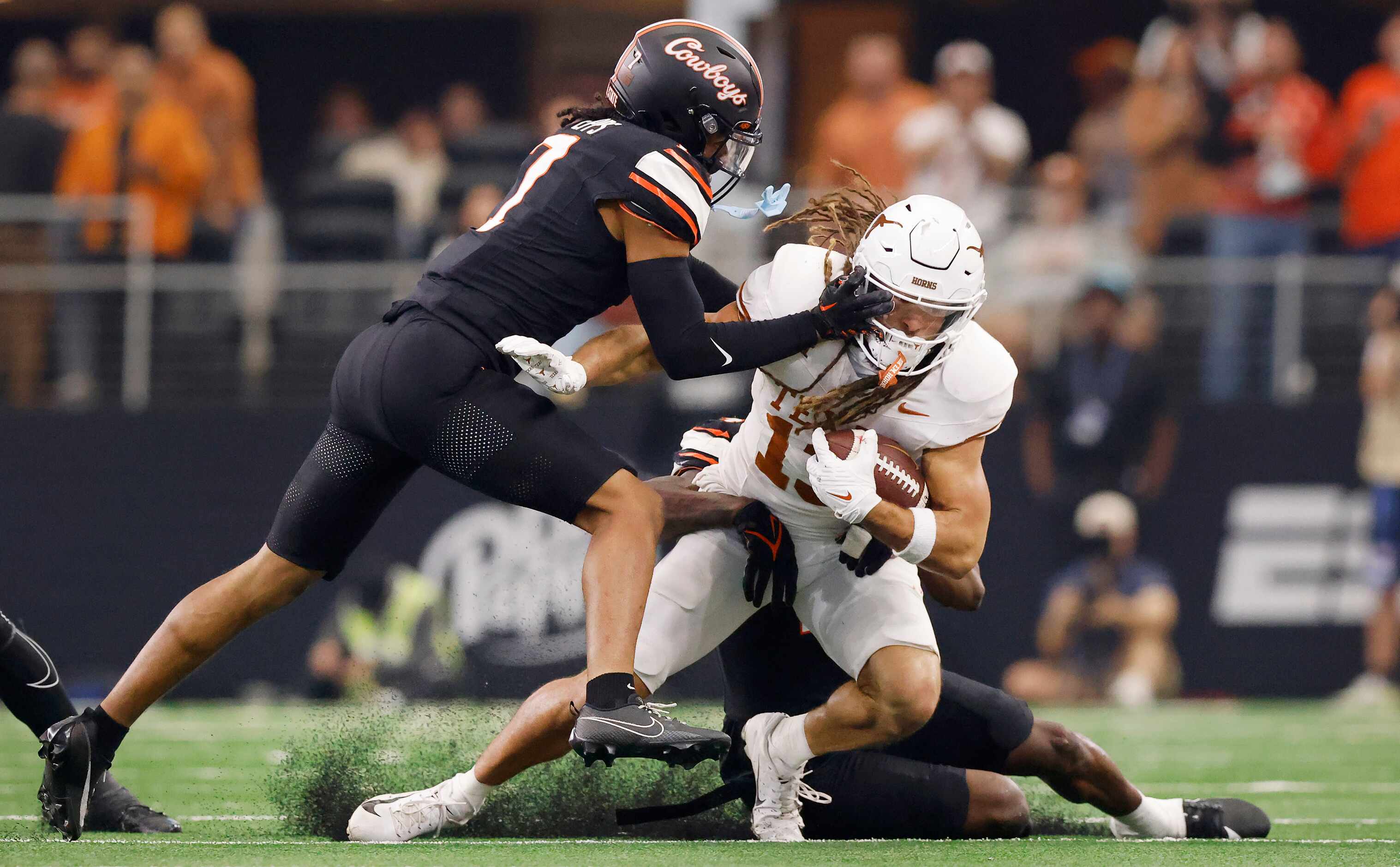 Texas Longhorns wide receiver Jordan Whittington (13) is tackled by Oklahoma State Cowboys...