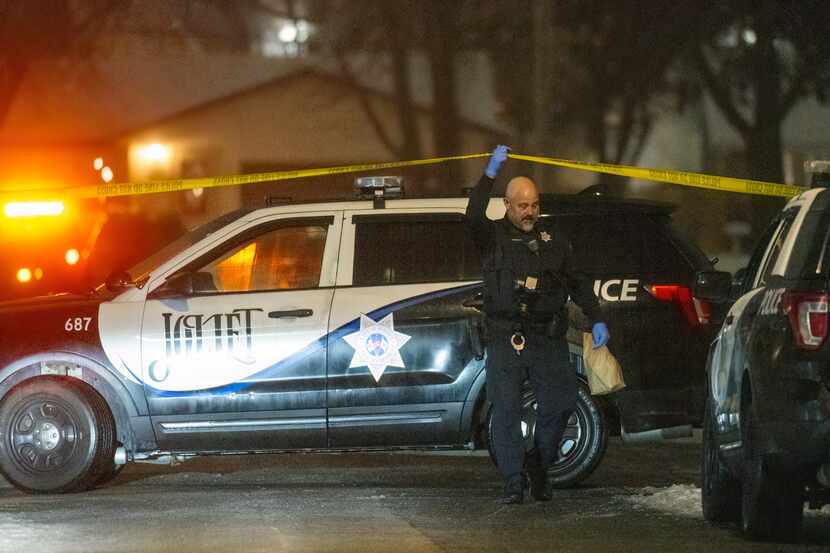Police work a scene, Monday, Jan. 22, 2024, in Joliet, Ill., after multiple people were shot...