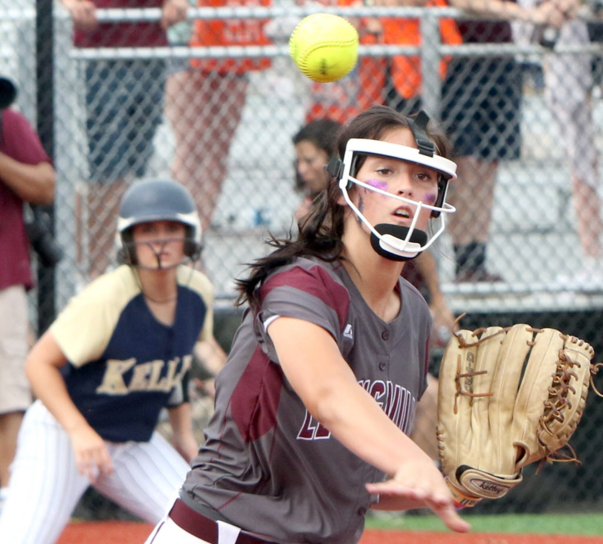 Lewisville pitcher Maribeth Gorsuch (12) looks the baserunner down at 3rd base before...