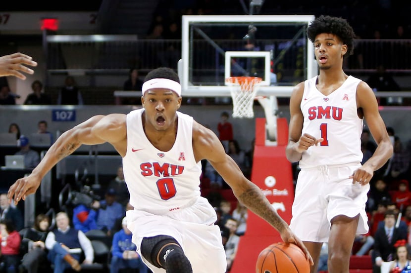 SMU guard Jahmal McMurray (0) drives the lane as forward Feron Hunt (1) looks on during...