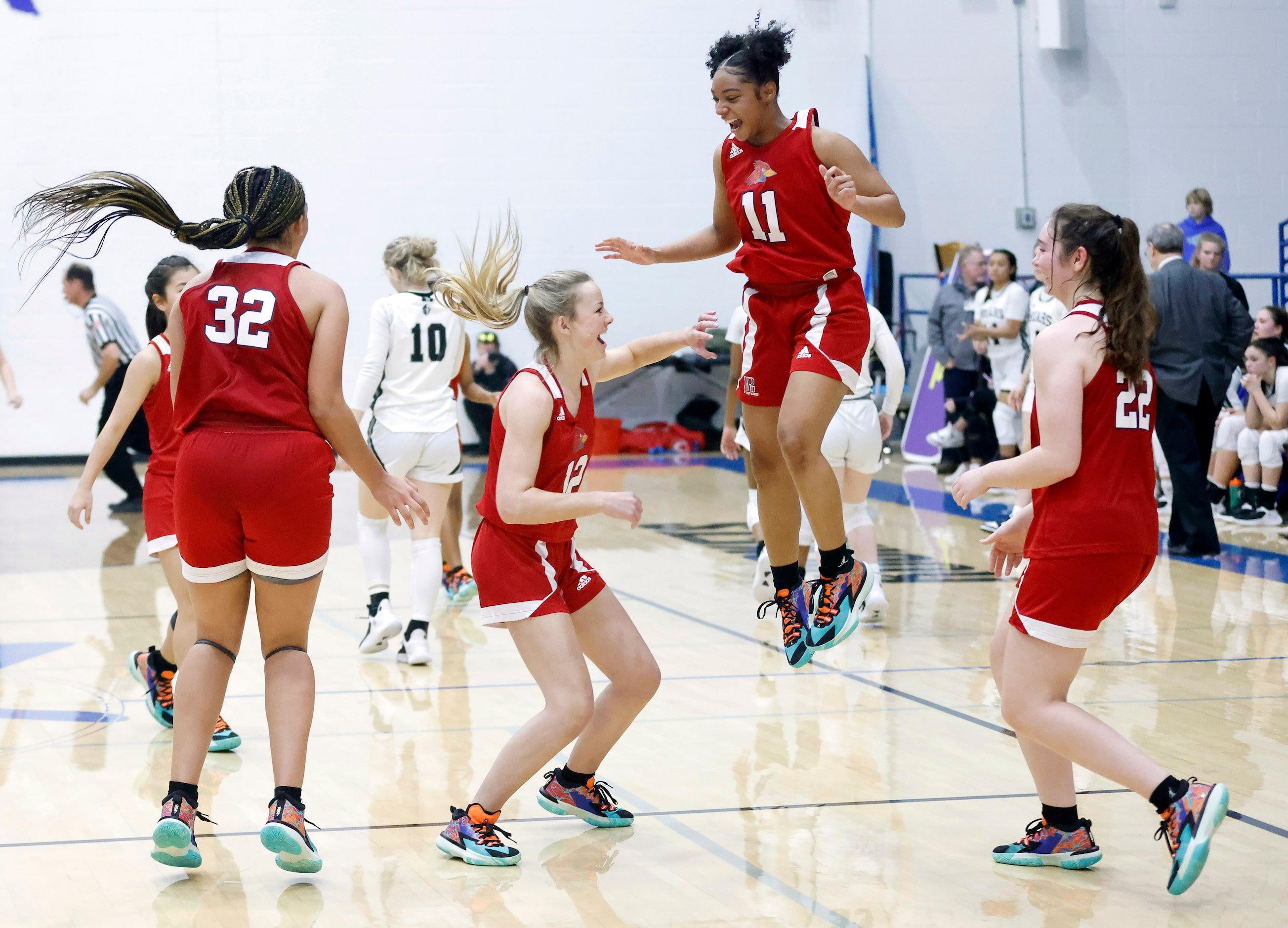 John Paul II players Allysia McDaniel (32), Madelyn Lee (12), Lydia Cooke-Wiggins (11),...