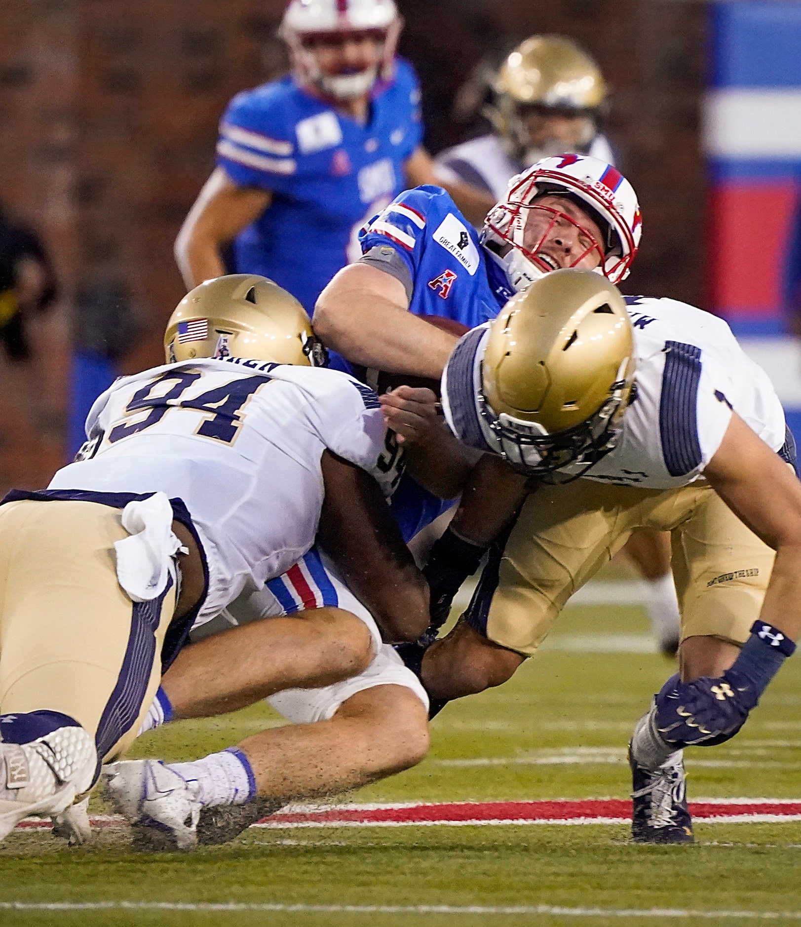 SMU quarterback Shane Buechele (7) is brought down by Navy defensive end J'arius Warren (94)...