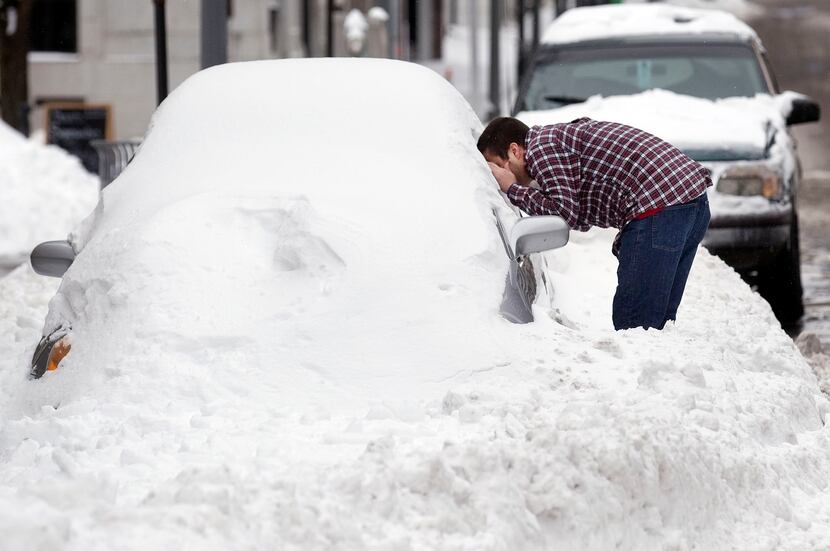  Anthony Perry of Roanoke, Va., peers into his car parked on Jefferson Street Saturday, Jan....