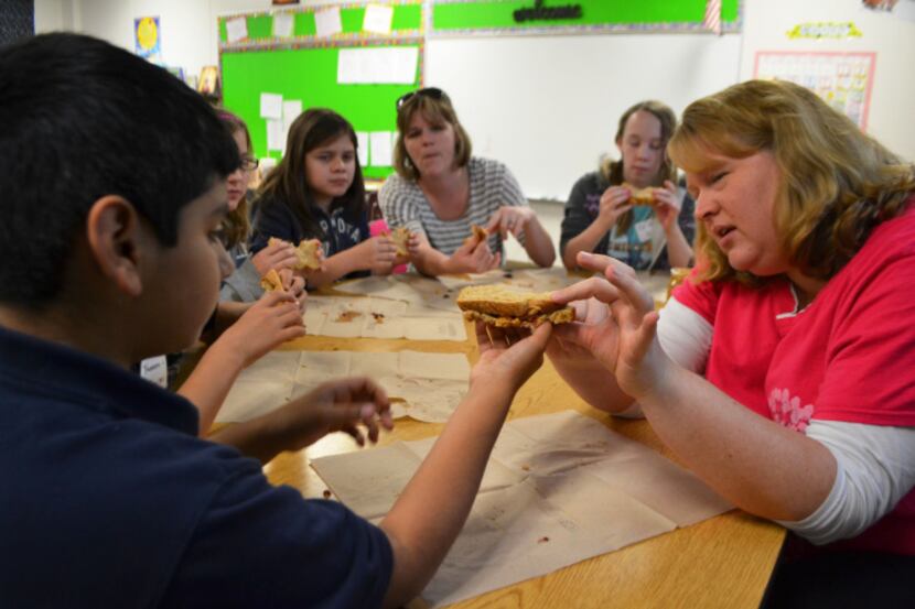 Teacher Michele Matz delivers a geology lesson to fifth graders using a peanut butter and...