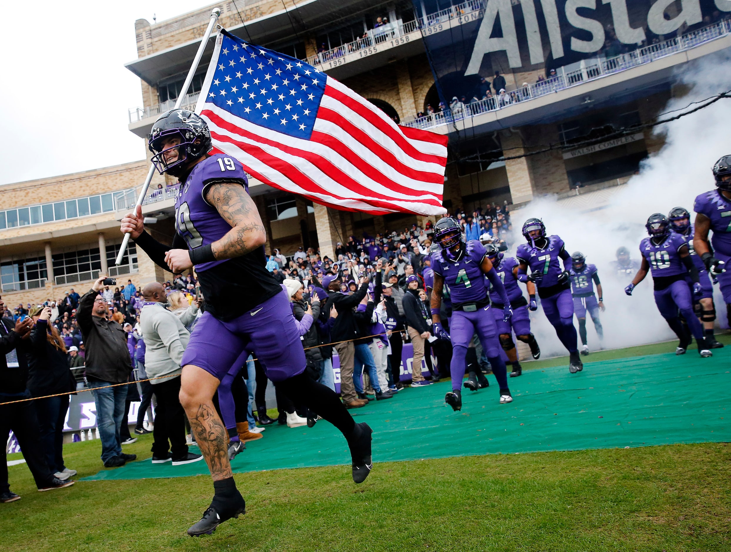 TCU Horned Frogs tight end Jared Wiley (19) carries the U.S. flag as the they take the field...