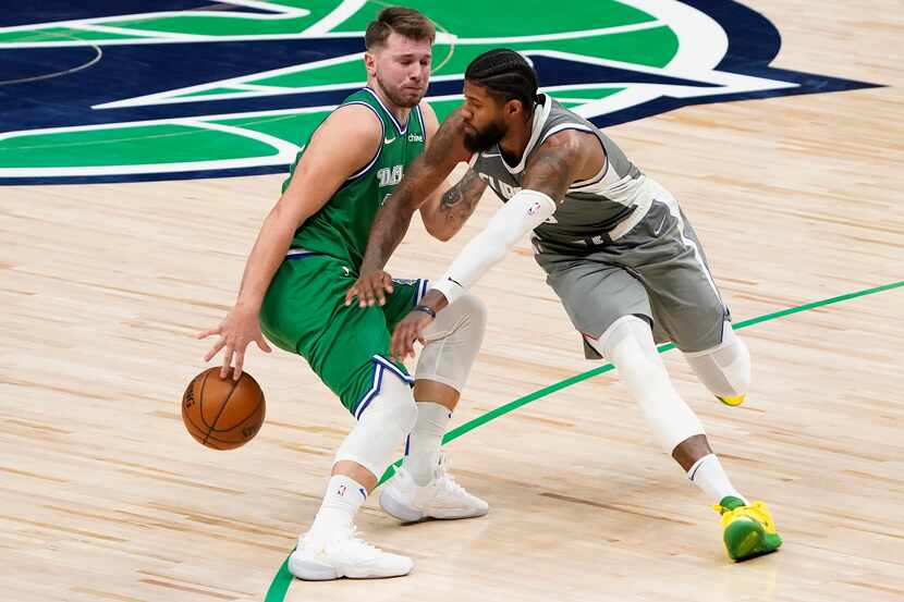 El jugador de los Mavericks de Dallas, Luka Doncic (izq), controla el balón ante el acoso...
