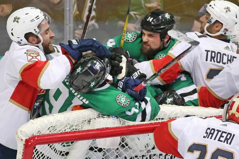 Dallas Stars left wing Jamie Benn (14) and center Tyler Seguin (91) fight with a host of...