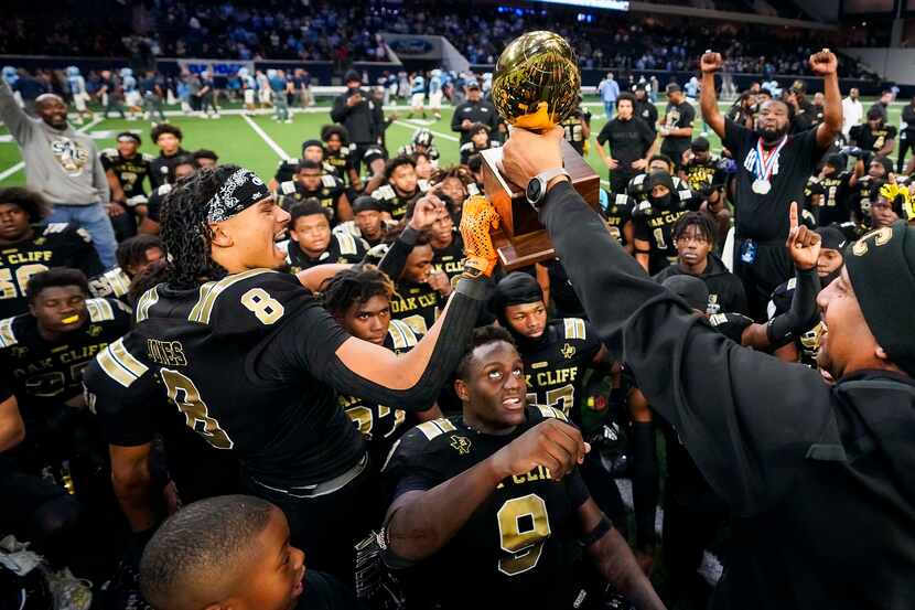 South Oak Cliff players celebrate with the championship trophy after defeating Frisco...