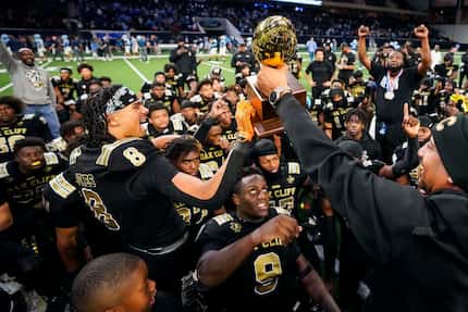 South Oak Cliff players celebrate with the championship trophy after defeating Frisco...