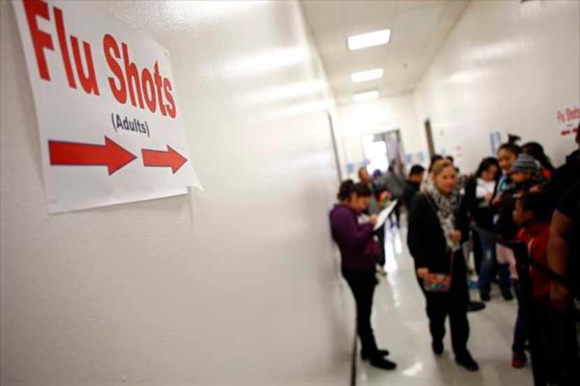 Area residents line up to get a flu shots Jan. 9 at Dallas County Health and Human Services...