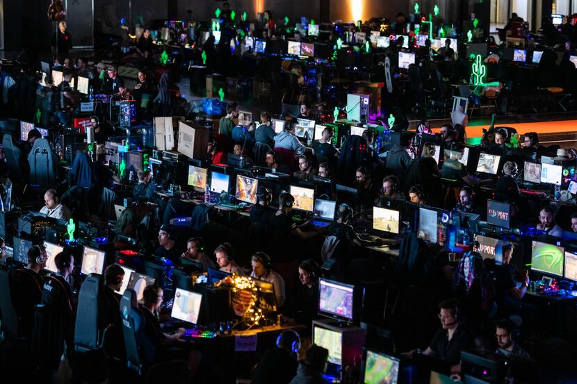 Participants sit at a computer monitor to play a video game at the 2019 DreamHack video...
