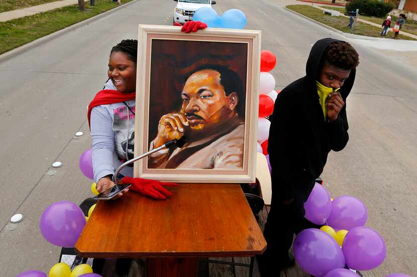 Pashon Vine (izq.) sostiene un retrato de MLK durante una marcha realizada en Garland, en 2019.