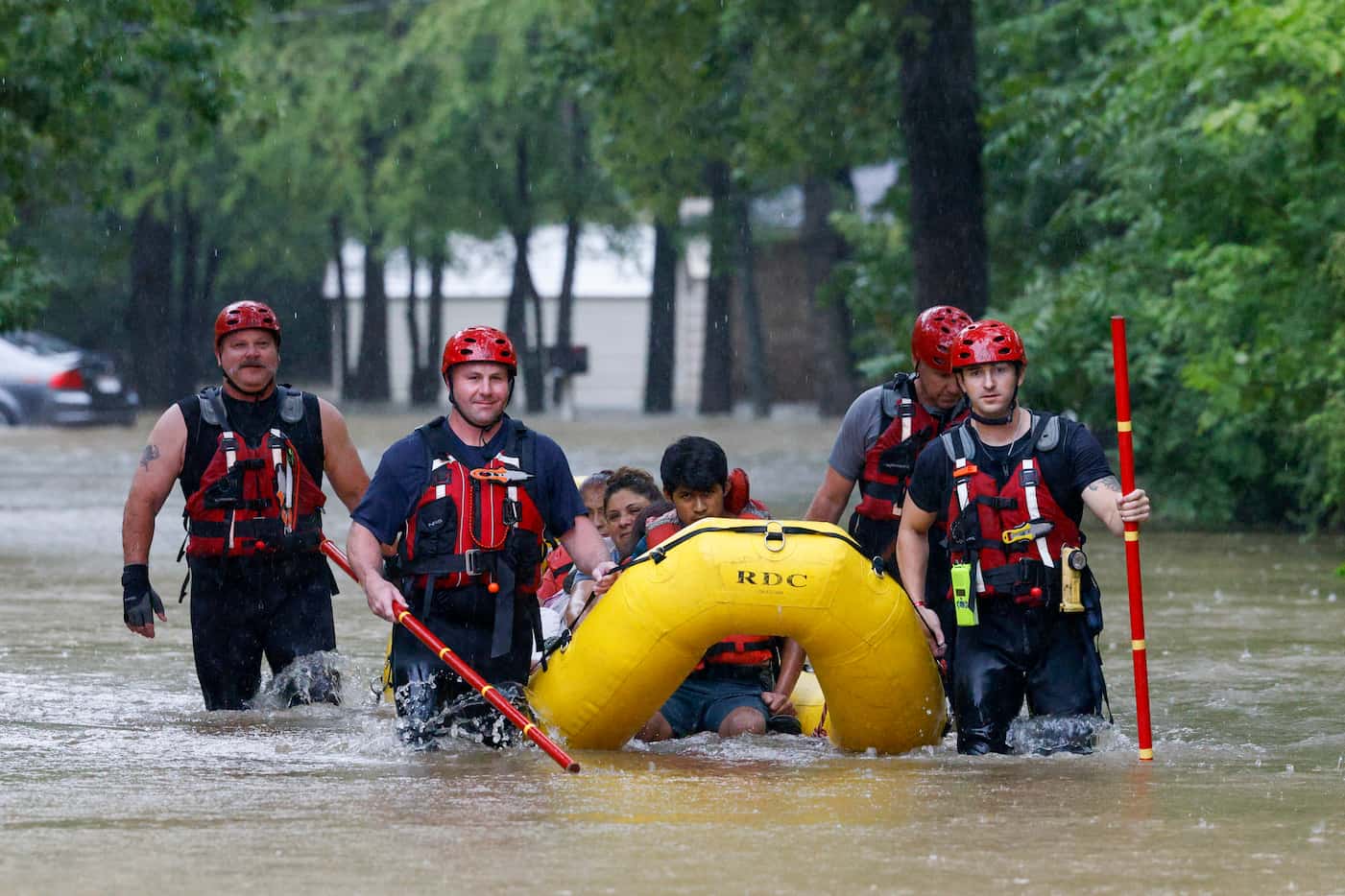 Members of the Balch Springs Fire Department bring a family of four by boat to higher ground...