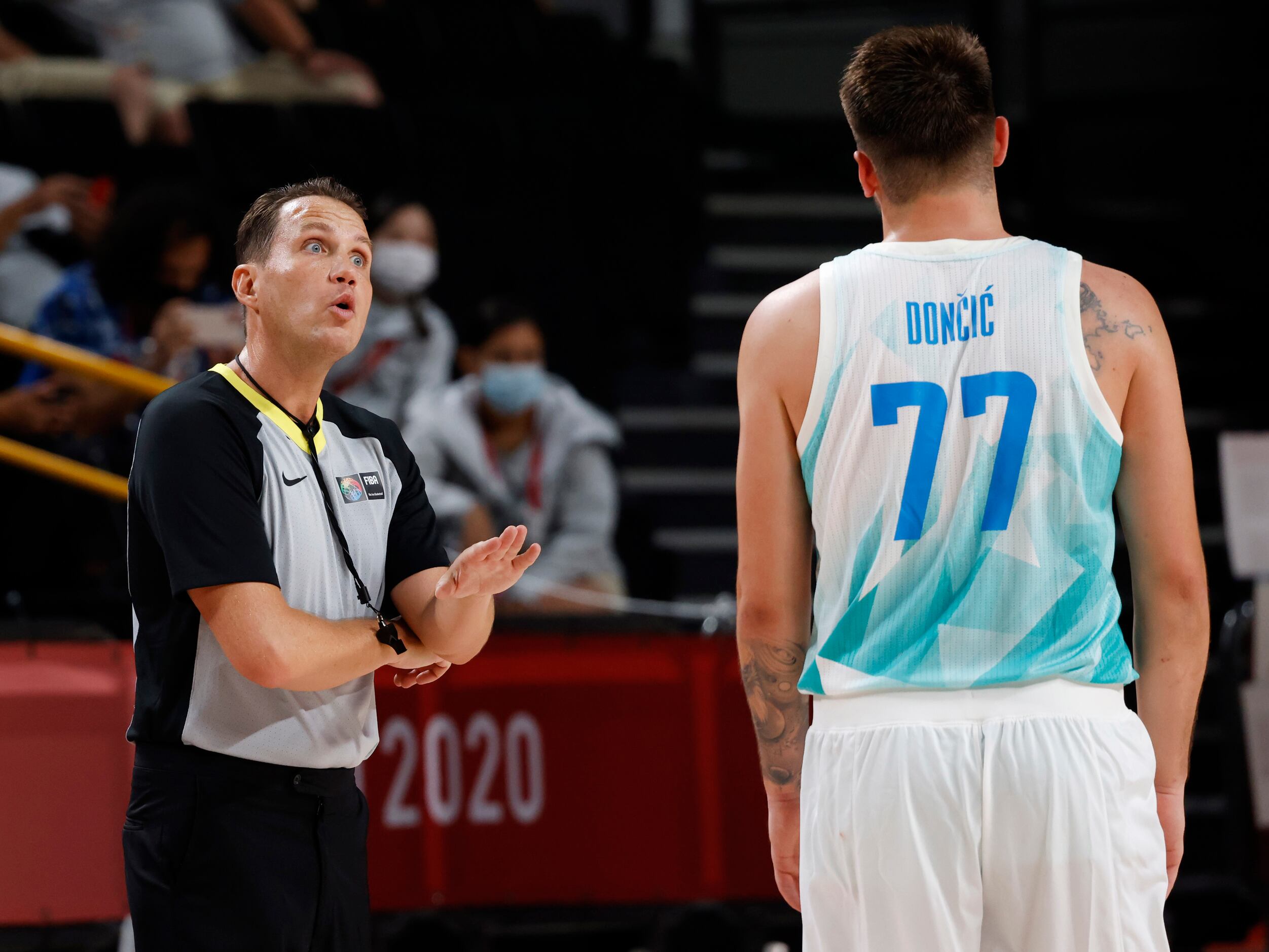 An official talks to Slovenia’s Luka Doncic in between plays in a basketball game against...