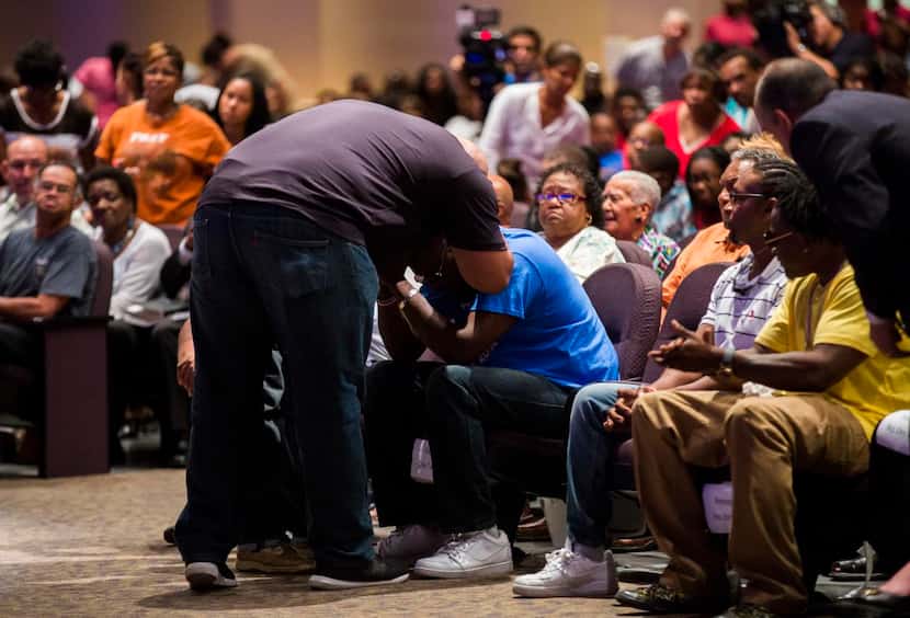 
Adrian Taylor Jr., brother of Christian Taylor, comforts his father, Adrian Taylor, during...