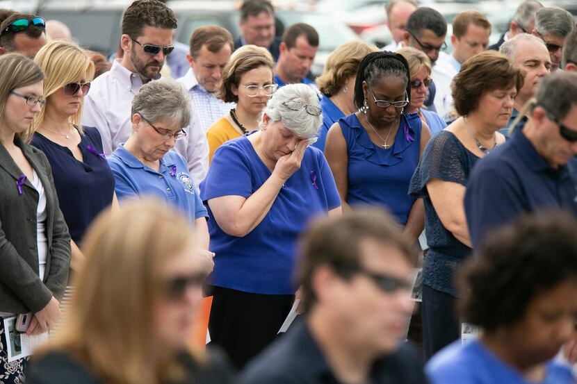 Mourners take a moment of silence during a memorial service for Christopher K. Rapp and the...