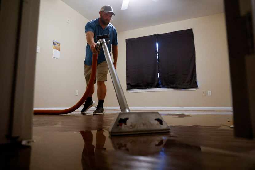 Jerry Owen, owner of Rez-CLN vacuums flood water collected in a house in Spring Oaks...