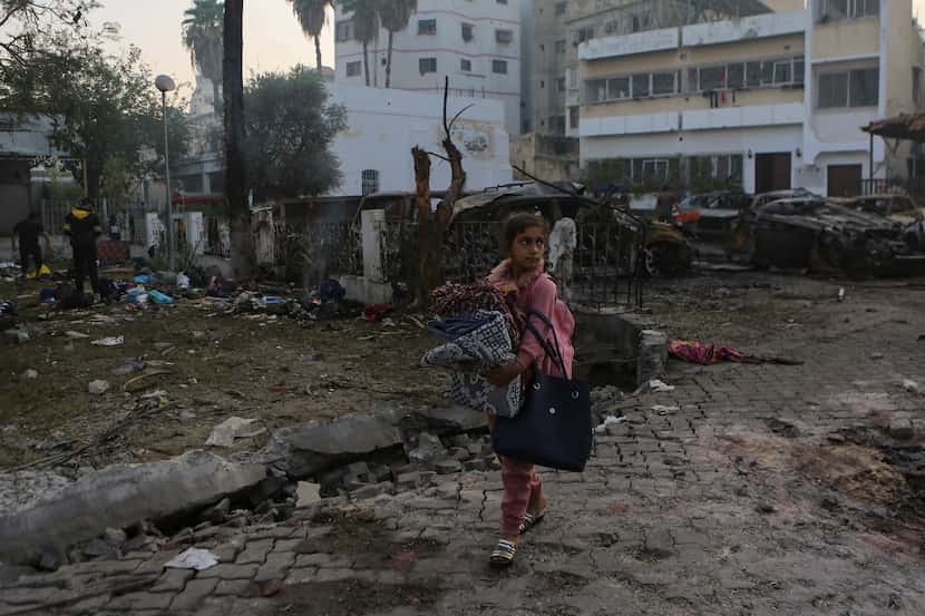 A Palestinian girl carried blankets as she walked past the site of an explosion last week at...