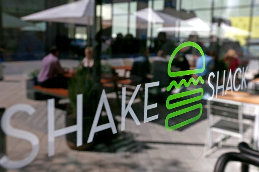 Diners are reflected in the door of Shake Shack in the mixed-use Legacy West development in...
