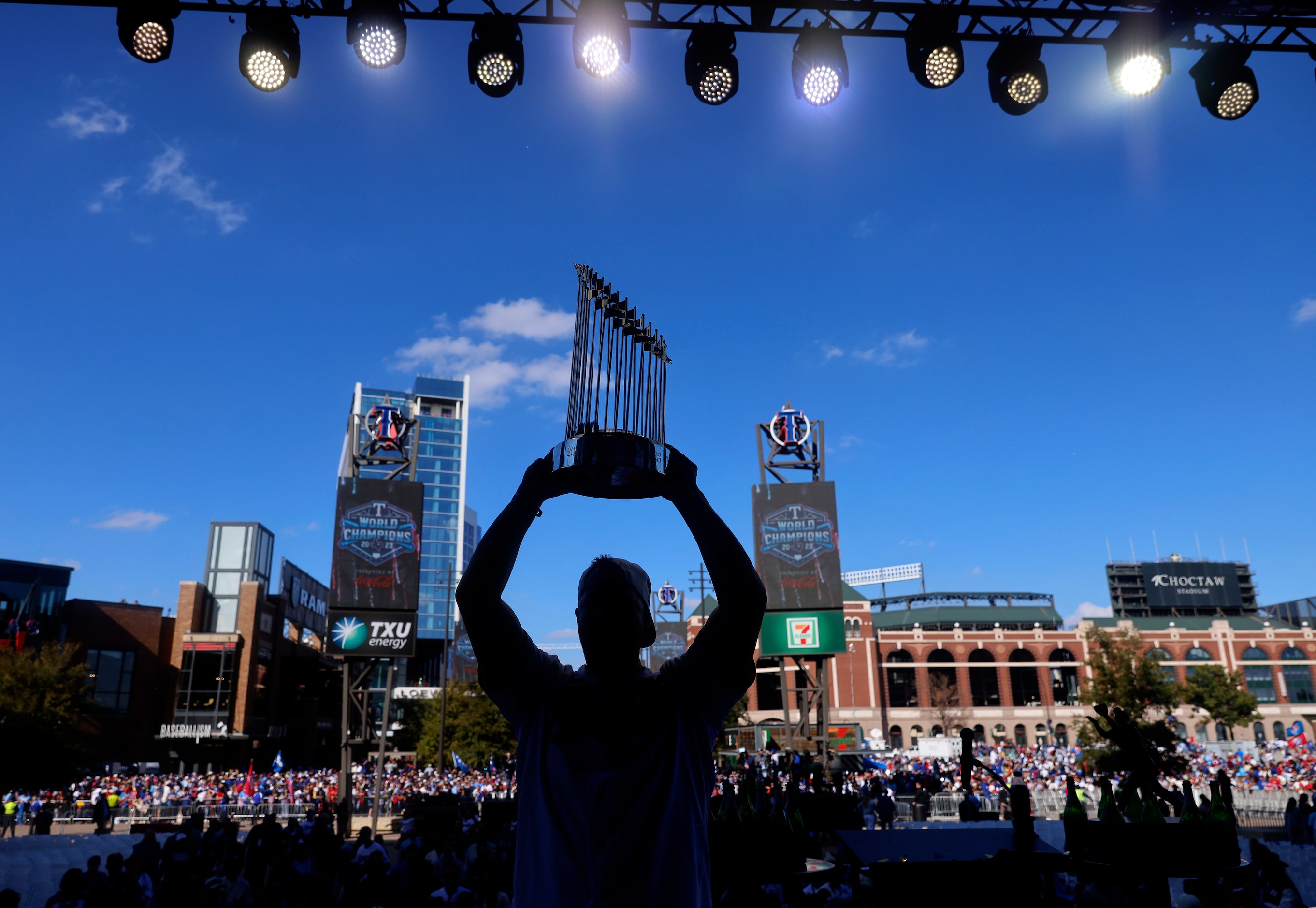 Texas Rangers left fielder Evan Carter hoists the Commissioner's Trophy for a family photo...