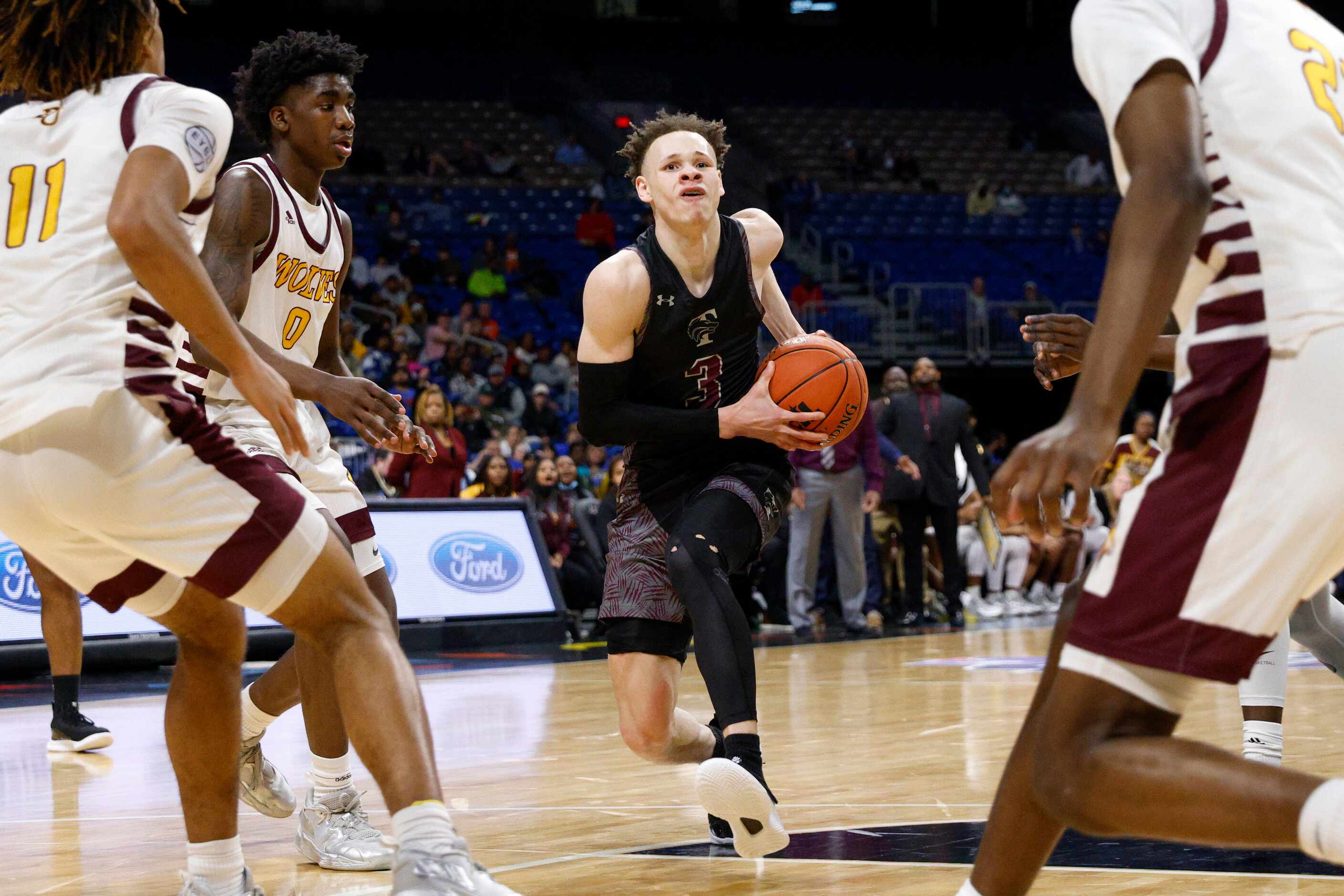 Mansfield Timberview guard Chendall Weaver (3) splits the defense of Beaumont United guard...